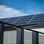 Close-up view of modern solar panels on a rooftop against a clear blue sky, representing clean energy.