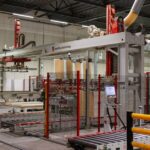 Industrial machinery with robotic arm in a modern manufacturing facility.